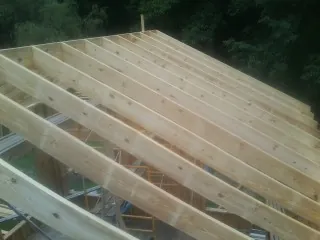 New roof rafters set over an addition before sheathing in Stedman