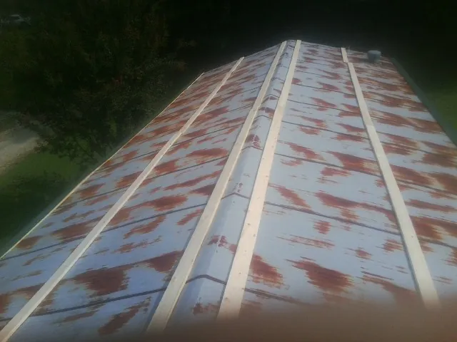 Rusted metal roof panels with new wood purlins before replacement — Storm Damage Roof Repair in Stedman by Roofing Brothers