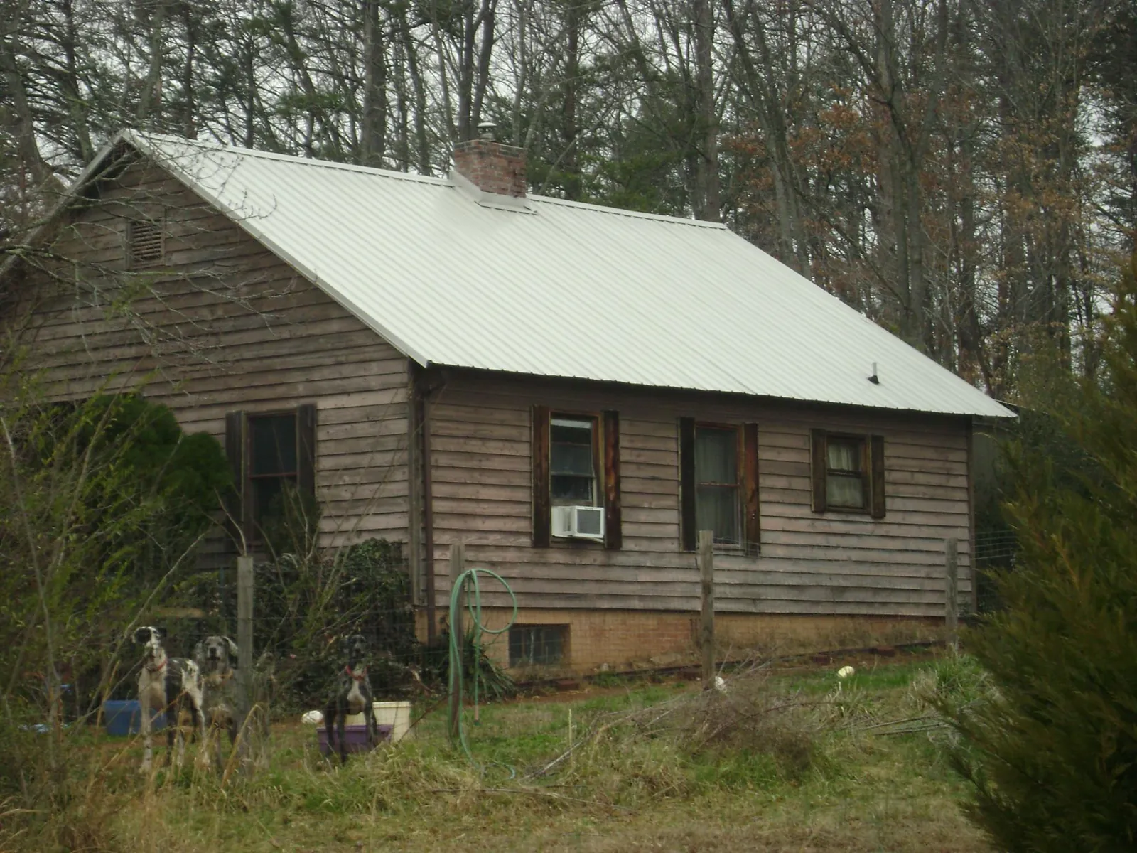 White metal roof on an old wood sided farmhouse, from a Metal Roof Installation job in Stedman